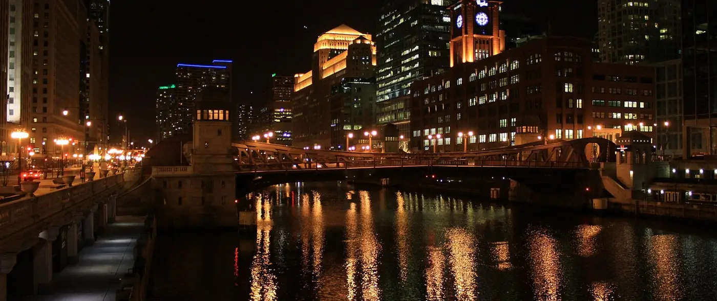 The Chicago River at night with lit buildings reflected in the water